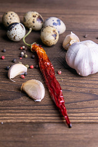 深色木质背景上的辣味大蒜红辣椒鹌鹑蛋特写镜头图片