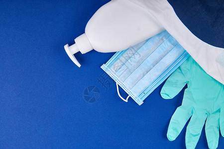 蓝色背景白袋中的防护医用口罩消毒凝胶和手套针对头孢细菌平躺的保护措图片