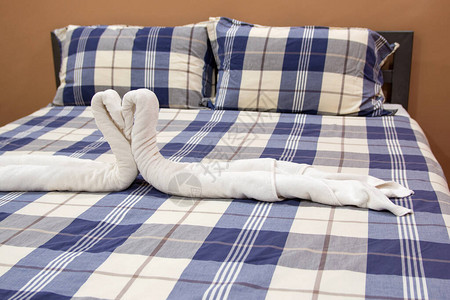 卧室内部装饰有枕头和毛巾的格子床图片