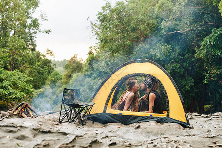 亲吻中年夫妇在营火旁边的帐篷图片