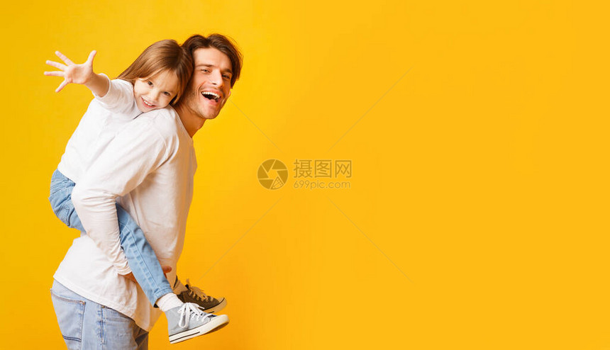 积极的爸把快乐的女儿抱在背上图片