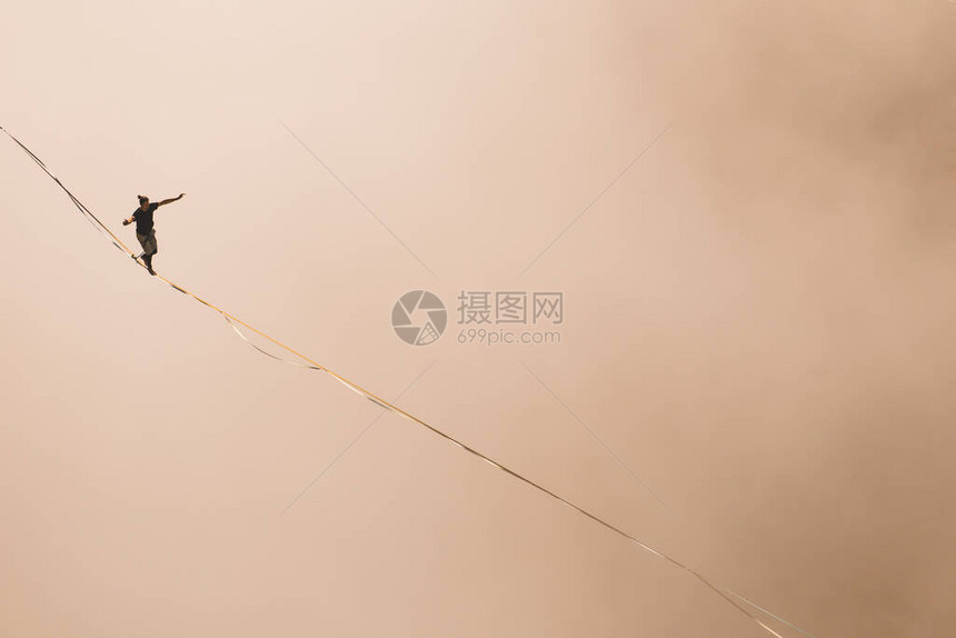 一个人沿着高在云层上方的拉长吊索行走highliner在峡谷中通过长而高的吊索拉力来保持平衡波斯尼亚和黑萨哥维图片