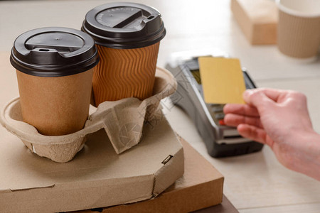 两个咖啡杯和比萨饼盒男人在背景中用信卡买的外图片