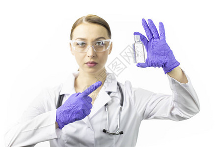 穿着医疗制服的漂亮女医生指着消毒凝胶分配器图片