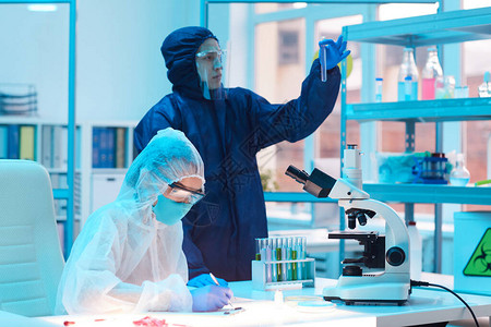 两位穿着生物危险装备在医学实验室研究的科学家的肖图片