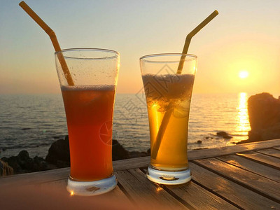 冷冻鸡尾酒杯在日落时用木图片