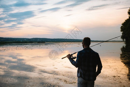 在日落时捕食鱼手的双轮船淡图片