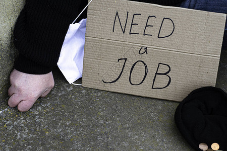 失业概念和失业冠状坐在旁边的地上图片
