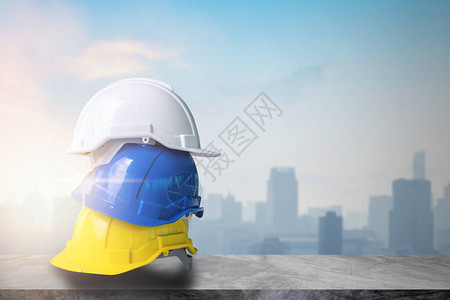 在甲板建筑和城市背景顶部的水泥桌上工作的黄色蓝色和白色建图片