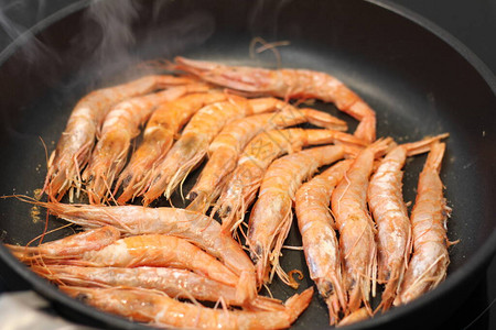 用平底锅在烤架上烹制的鲜红虾图片