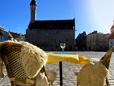 塔林古老的市政厅广场街头咖啡桌和中世纪人行道椅春天空城蓝天和阳光明图片
