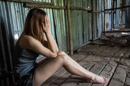 绝望的无家可归失业妇女坐在废墟小屋或房子上图片