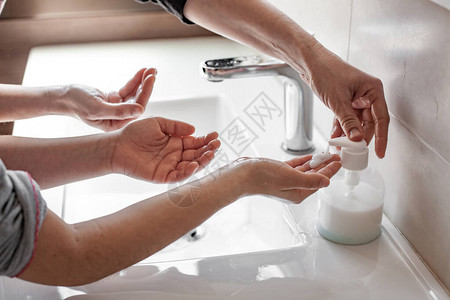 母亲教她女儿如何用肥皂洗手图片