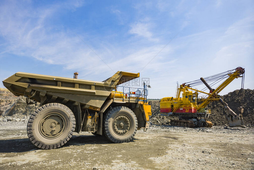 一台采矿挖掘机用花岗岩装载一辆巨大的卡车世界上最大的花岗岩采石图片