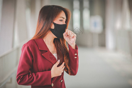 身戴面具保护Pm25和咳嗽的亚裔女在公众场合爆发Covid19图片