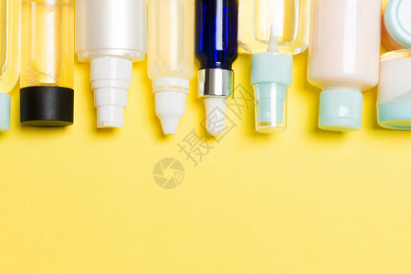 黄色背景的化妆品瓶和奶油瓶的平面成份图片