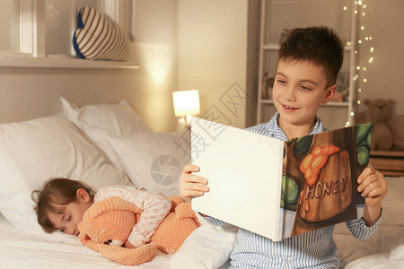 小女孩睡着了而她的兄弟在家读睡前故事图片