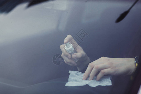 驾驶员使用含酒精的抗菌喷雾清洁汽车内部防止冠状病图片