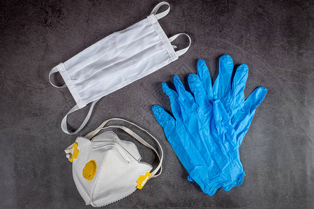 黑色背景的防护医用口罩呼吸器和手套图片