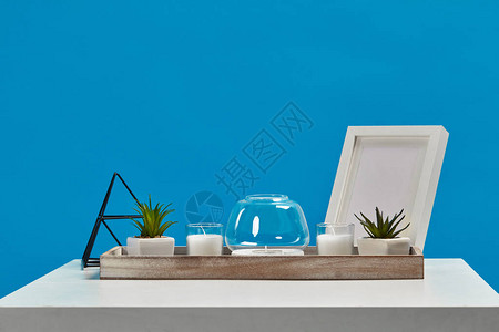 绿色的多肉植物在花盆里装饰铁三角和空相框蓝色背景室内设计关图片