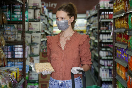 在超市杂货购物时戴保护面罩的妇女图片