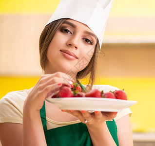 吃草莓的年轻女厨师图片