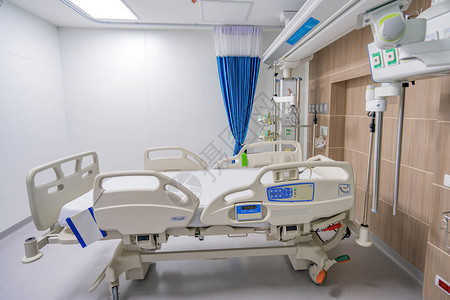 可调整的空病人床位在医院房间背景图片
