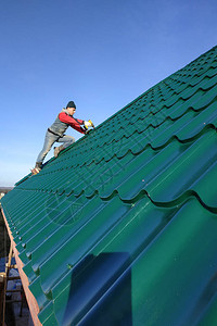屋顶工人在屋顶基地上挂有金属瓷砖图片