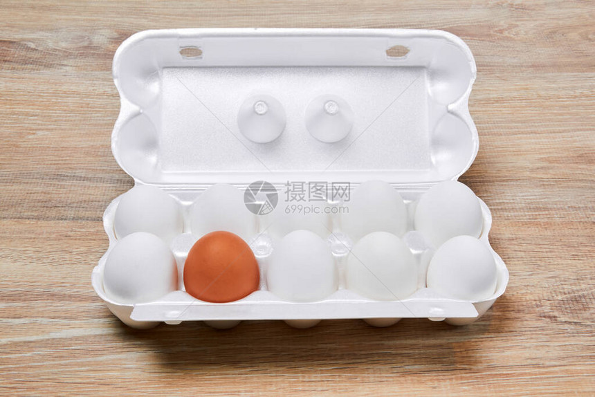 9个白蛋和1个棕色蛋一起包装在一个鸡蛋箱里图片