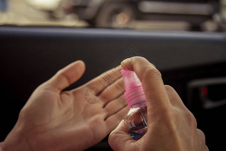 妇女在车内用酒精抗菌消毒剂洗手图片