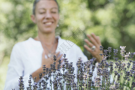 感恩自然美中年模特微笑着用手表达对大自然的感激之情通过自然治愈给予和图片