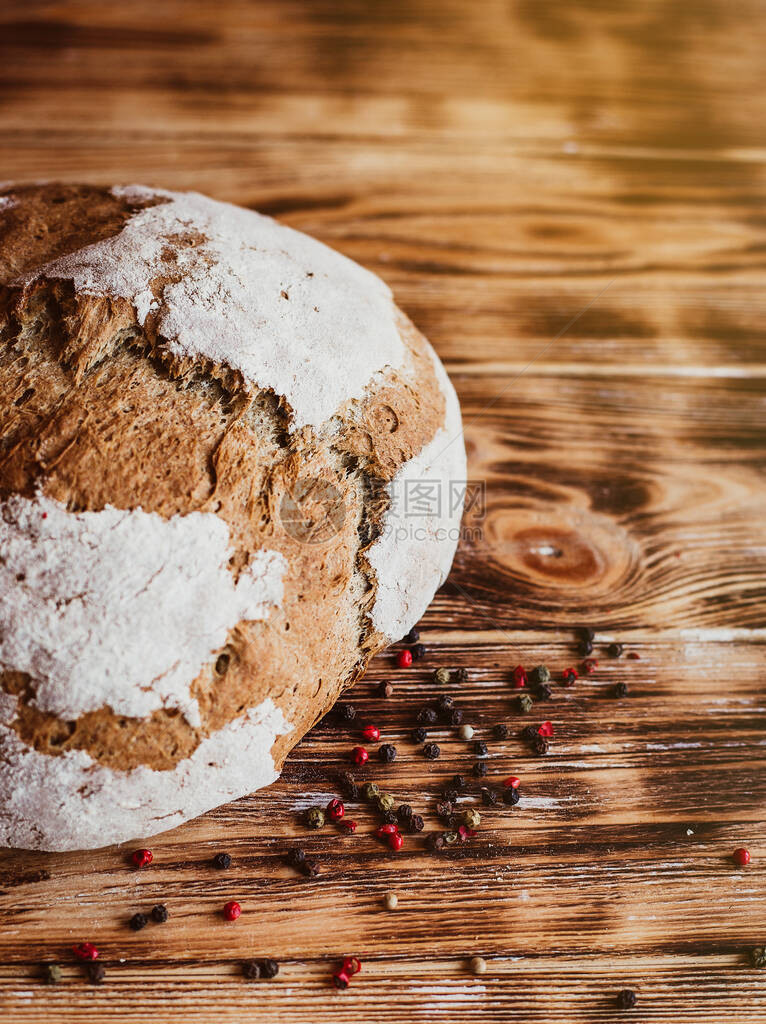 谷物工匠面包自制面包儿子深色木桌的质朴面包自创面包用香料俯视图适图片