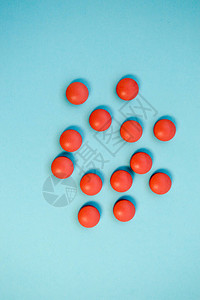 蓝色背景下用于治疗疾病的红色圆形药丸物图片