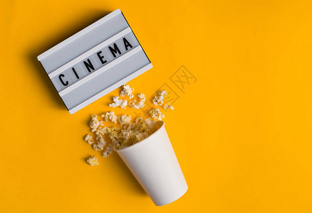 cinema花瓶里的爆米花和文字CINEMA在黄色背景的白色背景