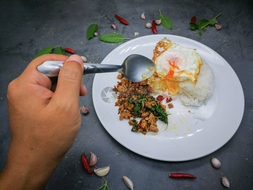 人类用手握着勺子吃米饭炸鸡蛋图片