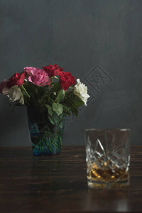 用玫瑰和一杯威士忌在木图片