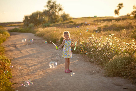 一个在田野里玩耍和吹肥皂泡的女孩图片