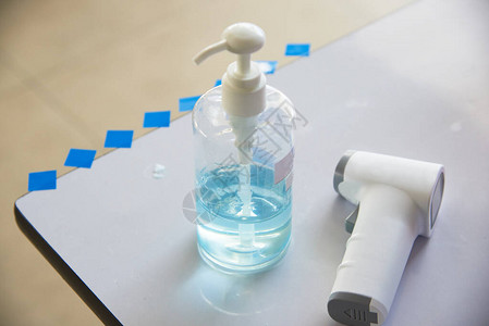 冠状感染的发烧筛查设备数字温度计瓶中酒精凝胶和桌子图片