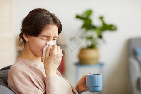 年青妇女有一个跑鼻子的鼻子在生病时喝图片