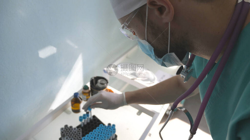 科学家用疫苗样本对冠状进行试管测试戴防护眼镜的年轻实验室工作人员检查COVID19的药物样本冠状大流行的图片