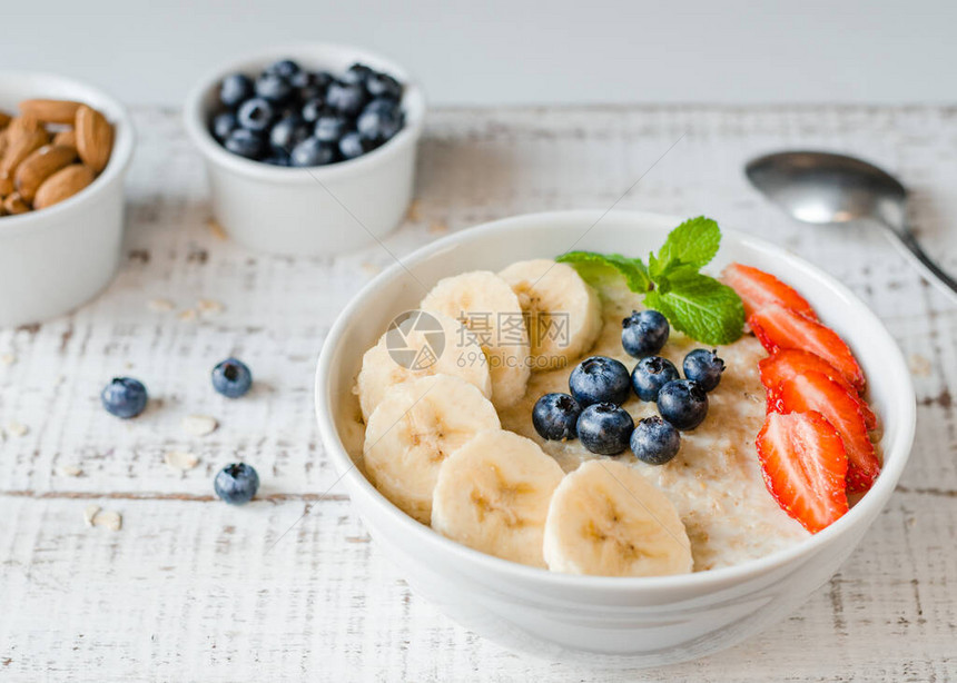 健康的早餐一碗粥里有蜂蜜浆果和茶特写镜头图片