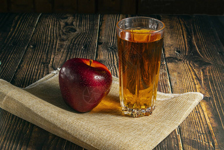 一篮子里的苹果放在黑底的木制桌子上图片