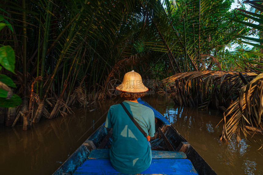 在南越BenTre的湄公河三角洲地区巡航戴维特名帽的旅游者通过椰子棕榈树种植图片