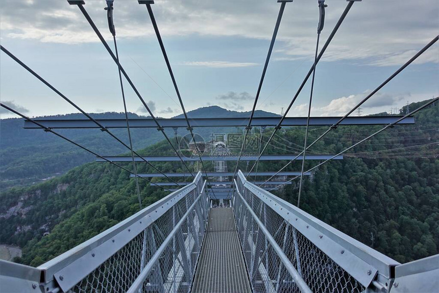 天桥是世界上最长的悬索天桥之一在深峡谷和河流上的金属和混凝土桥格子地板和栏杆图片