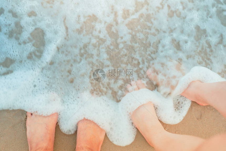 在沙滩上关闭一对夫妇的双脚夏季以柔软图片