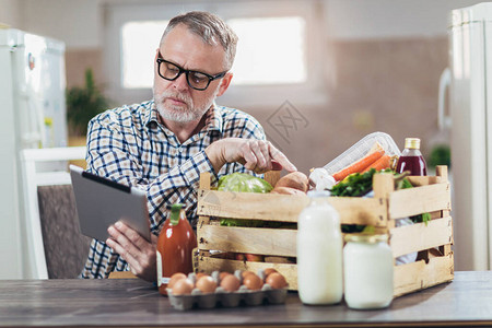 刚拿到有机食品的人使用数字平板电脑背景图片
