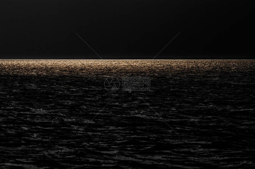 太阳的金色光芒反射在海面上图片