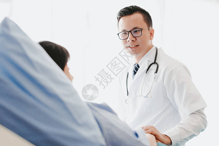 亚洲医生在医院病床上检查时给他的女病人建议图片