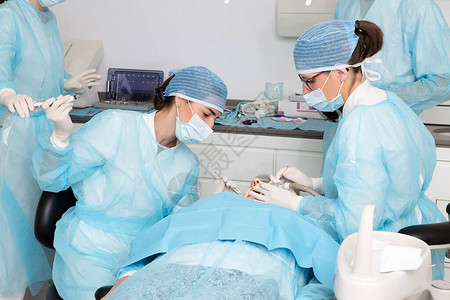女医生在现代诊所工作期间与同事一起治疗客户牙齿时图片