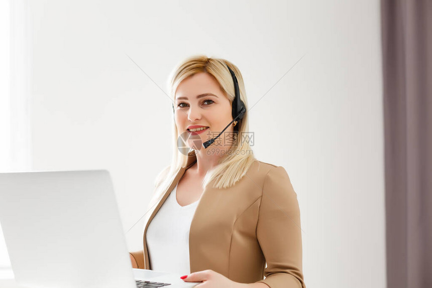 快乐的女人戴耳机笑使用笔记本电脑视频流电话会议在线教学图片